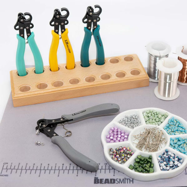 Jewelry-making tools and supplies including pliers and beads on a Beadsmith branded surface.