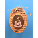 An oval Christmas ornament featuring a textured brown wood background with horizontal wood-grain stripes, a central metallic bronze oval containing a relief of the Holy Family and star, and a natural jute hanging string tied at the top.