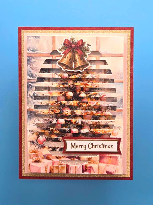A rectangular Christmas greeting card featuring a festive tree made from stacked books, decorated with ornaments, a red bow, and two gold bells at the top. The card has a red border, a gold inner border, and a 'Merry Christmas' label near the bottom, set against a solid blue background.