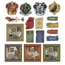 A sheet of Harry Potter themed scrapbooking paper or craft stickers featuring the four Hogwarts houses crests, house props, and house-themed labels on a white background.
