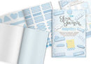 A styled flat-lay of a baby blue journaling kit, including a journal cover with 'Junk Journal baby clue' text, sheets of decorative stickers, patterned paper, and lined paper on a white background.