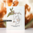 A handmade greeting card by Penny Black featuring a cute white ghost reading a book on a swing, with a green leaf branch and the sentiment 'I've got an un-boo-lievable story for you'. The card is displayed against a warm, blurred autumn background.