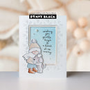 A handmade greeting card featuring a white embossed snowflake border, a light blue central panel with the words 'wishing you gentle hugs & a heart so-so merry', a cute illustration of a child hugging a dog, and a black 'Penny Black' brand banner at the top. The card is photographed on a light gray surface with a warm, blurred background.