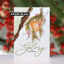 A handmade greeting card featuring a white background with a layered paper cutout design. The design includes a brown bark texture on the left, a watercolor green pine garland with a central orange heart ornament and small red berries, and the words 'Glory in the stillness' in olive green script.