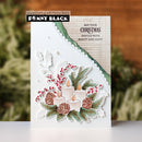A handmade Christmas greeting card by Penny Black, featuring layered white die-cut paper elements with candles, pinecones, holly leaves, and red berries, set against a blurred holiday background.