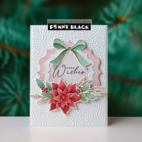A handmade layered Christmas greeting card by Penny Black, featuring a white embossed background, a pink scalloped arch, a mint green bow, red poinsettias, holly leaves, and the words 'Warm Wishes'.