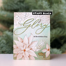 A handmade greeting card featuring watercolor poinsettias, white snowflakes, and gold foil script reading 'Glory to the newborn King' with 'Penny Black' branding on a blurred green background.