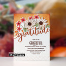 A handmade gratitude card featuring layered die-cut flowers in white, pink, and orange on a textured orange and white background, with the word 'gratitude' in large cursive script and a quote by Margaret Proft. A Penny Black logo is visible in the bottom-left corner.