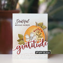 A handmade greeting card featuring a layered autumn design with a stamped orange pumpkin, white flower, green leaves, and the words 'grateful beyond words' and 'gratitude'. A small brand label at the bottom reads 'papercrafting with Penny Black' and 'PENNY BLACK'.