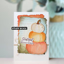 A handmade greeting card featuring three stacked watercolor pumpkins in white, orange, and peach, layered over a distressed light blue and green background. The card has a rustic orange border, a small pearl bow, and the text 'Grateful BEYOND WORDS' and 'papercrafting with Penny Black PENNY BLACK'.