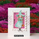 A handmade greeting card featuring a die-cut stamp design of a witch in a teal dress and hat against a pink spiderweb background, with decorative patterned borders and a visible Penny Black brand mark at the bottom.