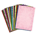 A fanned stack of patterned paper sheets, with the top sheet in light pink featuring a delicate pink floral border design, shown against a plain white background.