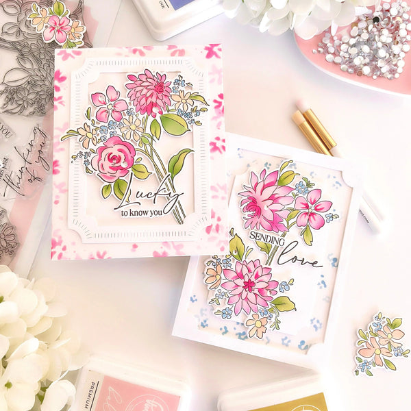 Floral cards with decorative elements on a table with flowers and stationery.