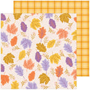 A sheet of patterned paper with an autumn leaf print in orange, yellow, purple, and peach on a cream background, layered over a second sheet showing a matching yellow-orange plaid pattern.