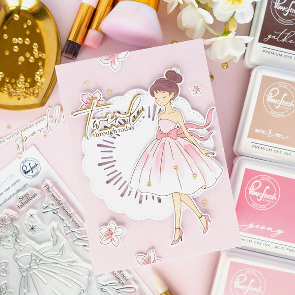 Stamps and stamping supplies with a decorative card featuring a fairy design on a pink background.