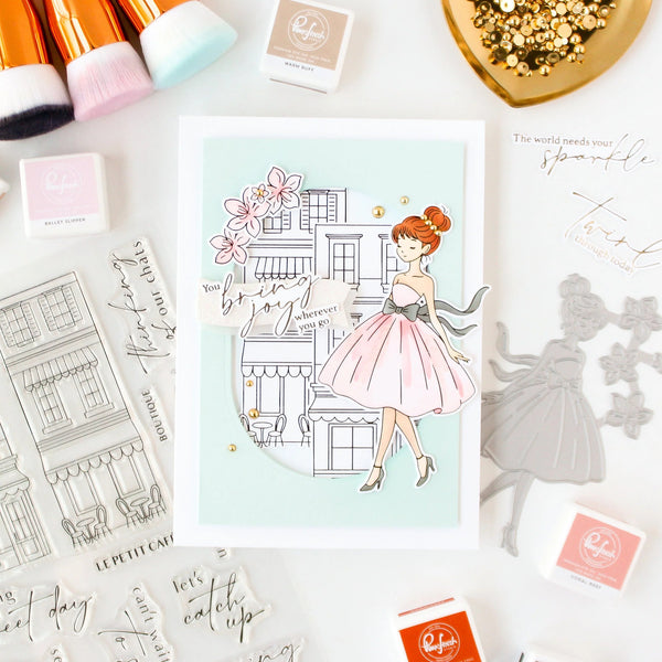 Illustration of a woman in a dress with buildings and flowers on a card, surrounded by related products.