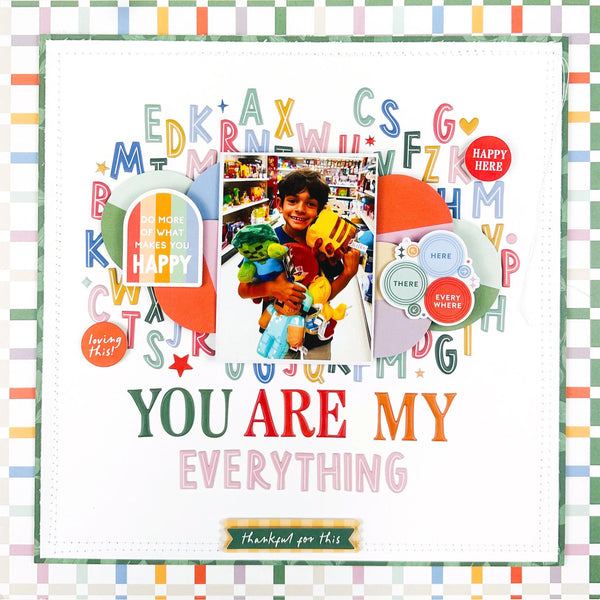 A square scrapbook-style card or print with a white center, colorful decorative letters, circles, stars, and a central photo of a smiling boy holding stuffed animals. Large text reads 'YOU ARE MY EVERYTHING,' with smaller text including 'Thank you for this' and 'loving you!'.