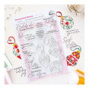 A sheet of clear photo stamping plates with holiday ornament and script stamp designs, displayed on a light surface with decorative Christmas ornaments and crafting tools around it. The sheet is branded 'Ornamental Beauty' and includes the 'Peaches' brand mark.