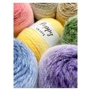 A close-up of several skeins of yarn in pastel colors, including pink, yellow, blue, purple, green, and beige, with a white label reading 'Poppy CRAFTS' wrapped around one yellow skein.