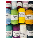 Nine skeins of Poppy Crafts yarn arranged in a grid, showing a variety of colors including red, light blue, green, yellow, orange, teal, purple, white, and gray. Each skein has a white paper label wrapped around it with the brand name 'Poppy Crafts' printed on it.