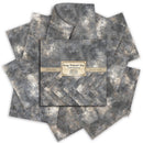 A stack of textured gray and beige patterned paper sheets arranged in a fan shape, with a central label reading 'Gray Distressed Gray' and smaller text about craft and cardstock paper.