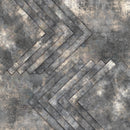 A textured gray and black geometric pattern featuring layered chevron or arrow-like diagonal bands with a distressed, concrete-like finish.