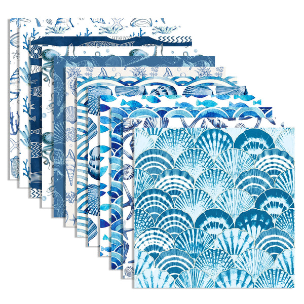A set of square fabric or paper sheets fanned out on a white background, each featuring blue and white nautical and shell patterns.