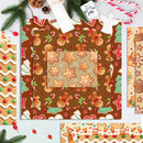 A flat lay of Christmas-themed patterned papers with gingerbread cookies, candy canes, ornaments, evergreen branches, and holiday decorations on a light background.