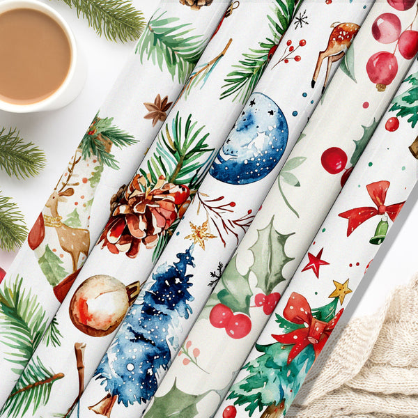 Six rolls of Christmas-themed wrapping paper are arranged diagonally on a white surface, decorated with festive watercolor illustrations including pine trees, holly, ornaments, stars, and deer. A cup of coffee and a knitted sweater are styled as props in the corners.