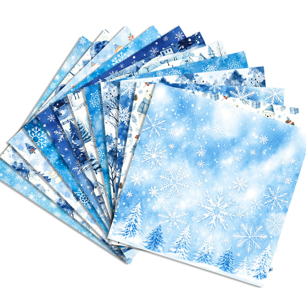 A fan of patterned paper sheets with winter-themed designs, including snowflakes, snowy trees, and blue-toned winter scenes, arranged on a white background.