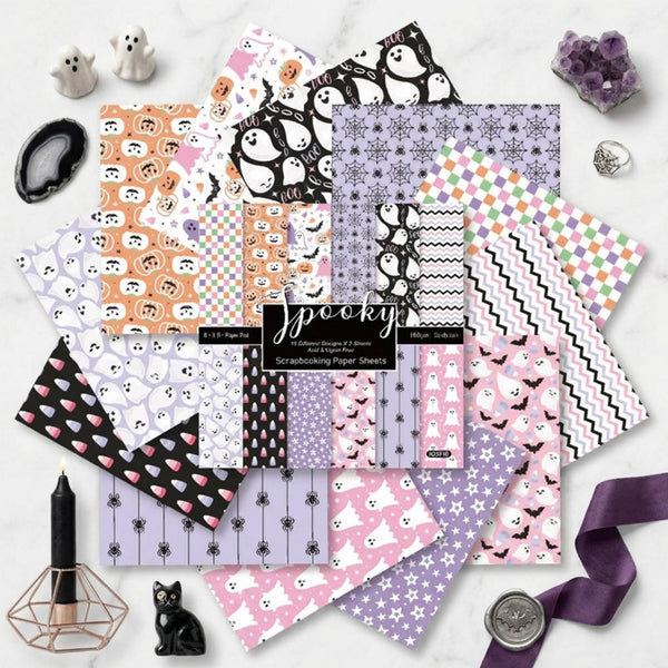 Collection of Halloween-themed scrapbooking paper sheets on a white surface with decorative items.