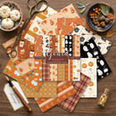 Collection of Halloween-themed scrapbooking paper sheets on a wooden surface with decorative items.