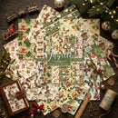 A flat-lay display of Mytte Christmas-themed scrapbooking papers on a dark wooden background, surrounded by festive props like a train, sleigh, lights, twine, scissors, and a small journal.