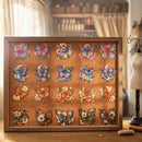 A framed butterfly art print featuring 16 colorful illustrated butterflies on a warm brown background, displayed on a wooden table in a softly lit room with a mannequin dress form and vintage lamp nearby.