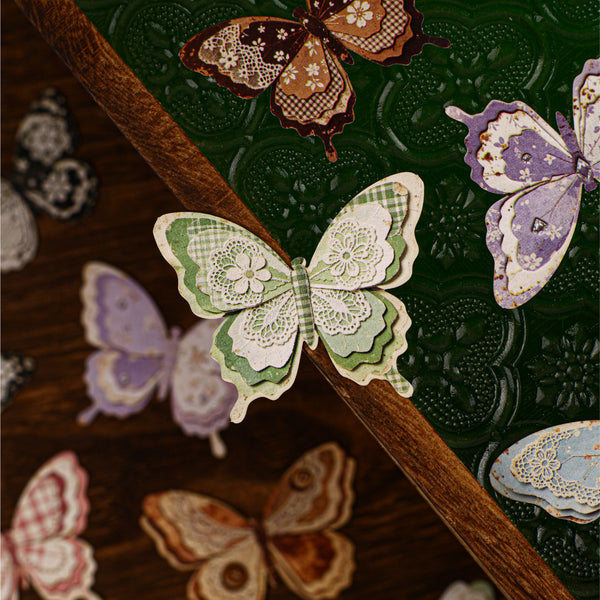 Decorative paper butterflies on a wooden surface with a green textured background
