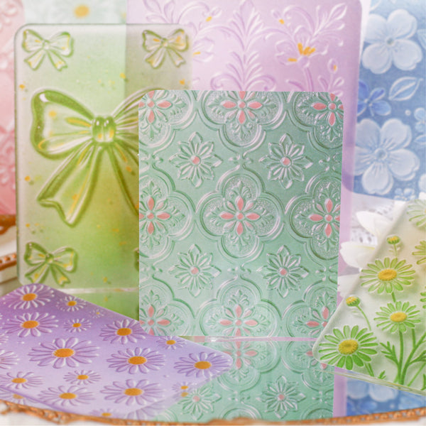 Collection of embossed paper sheets with floral and butterfly designs in pastel colors.