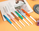 Set of colorful pens on a book with a yellow background