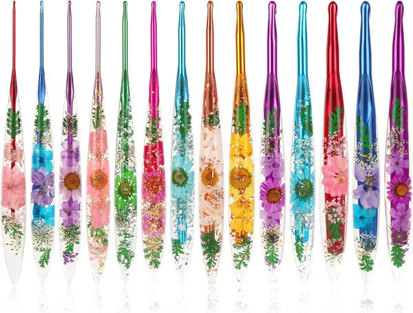 Twelve clear glass nail art tools with colorful metallic handles and embedded pressed flowers, arranged in a row on a white background.