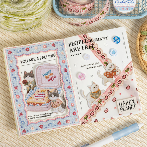Open book with cat-themed pages on a textured surface with yarn and crochet items.