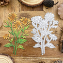 Metal floral cutting dies on a wooden surface with natural elements.