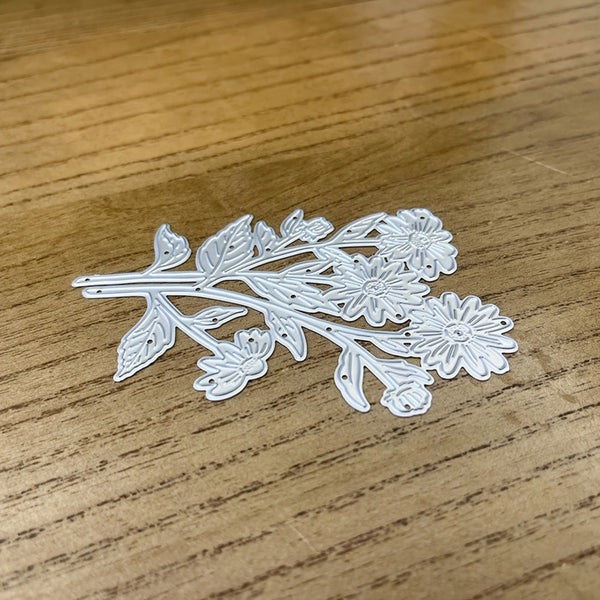 Decorative metal flower cutting die on a wooden surface