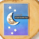 Card with moon and stars design on a wooden surface