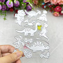 A hand holds a metal dinosaur die-cut template sheet featuring various dinosaur silhouettes and footprint outlines, with a background of white fabric and decorative flowers.