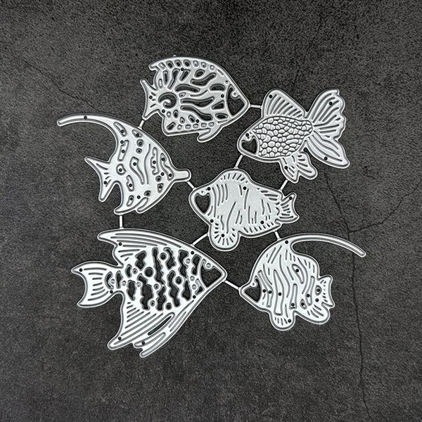 A set of seven silver metal fish-shaped wall hooks or ornaments arranged in a circle on a dark textured background.