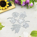 Six silver metal fish-shaped die-cut templates arranged on a light wood surface, with decorative flowers and leaves around the edges.