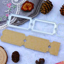 A metal die-cut craft cutting template shown with a matching tan paper sample on a white textured surface, surrounded by decorative pinecones, fabric, and a dried flower.