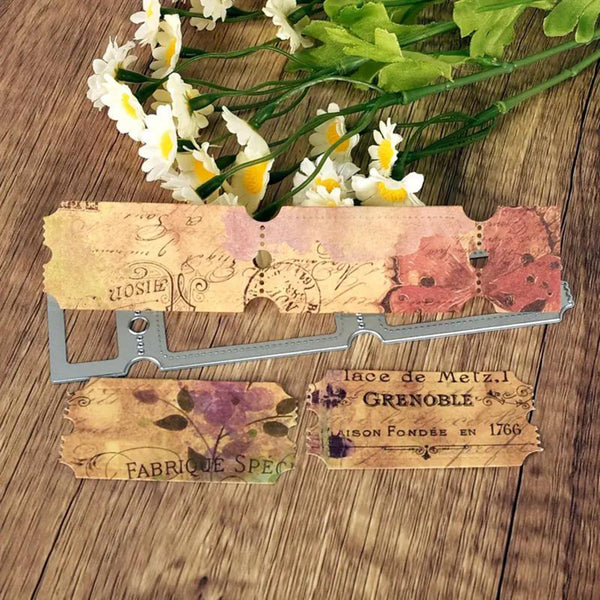 A set of vintage-style decorative paper tags with floral and script designs, displayed on a wooden surface with white daisies in the background.