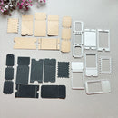 A set of paper crafting dies and matching paper templates arranged on a light beige surface. The set includes dark charcoal gray and light beige embossed paper tickets, rectangular and scalloped die-cut templates, and white metal stamping dies.