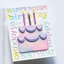 A handmade layered paper birthday card featuring a 2-tier cake with pastel pink, blue, and purple gradients, topped with two lit candles. The card is decorated with 3D bubble letters spelling 'HAPPY birthday BIRTHDAY' in a pastel rainbow color scheme, set against a clean white background.