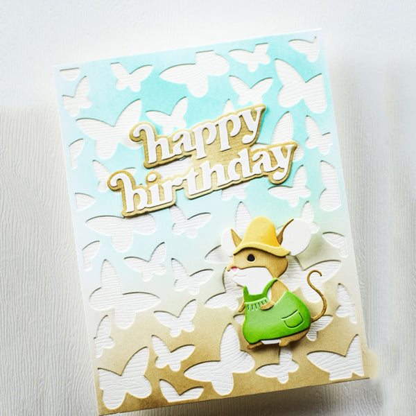A handmade greeting card featuring a light blue to cream gradient background with layered white butterfly cutouts. The card has a raised gold foil 'happy birthday' text and a 3D mouse character wearing a yellow hat and green outfit at the bottom right.